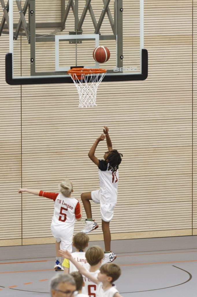 Vier-Felder-Halle eingeweiht 5 Ein Junge wirft einen Basketball in den Basketballkorb.