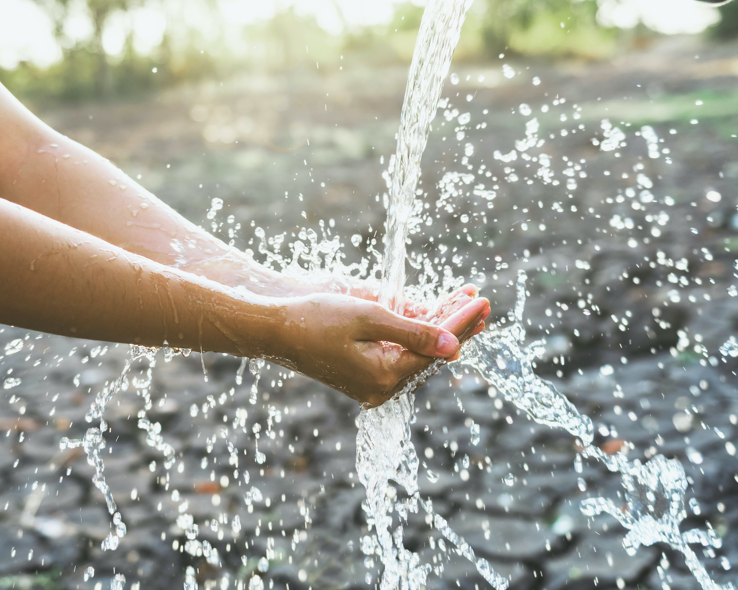 Wasser fließt in geöffnete Handflächen
